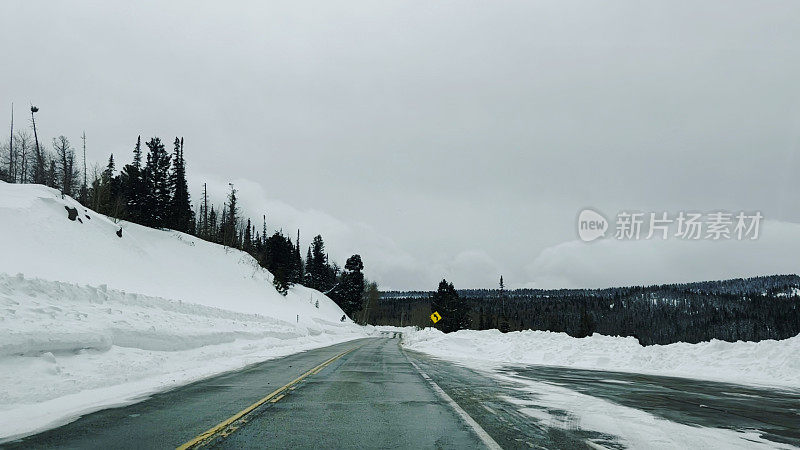 司机POV下雪的冬季山路与高雪堤在科罗拉多州西部照片系列