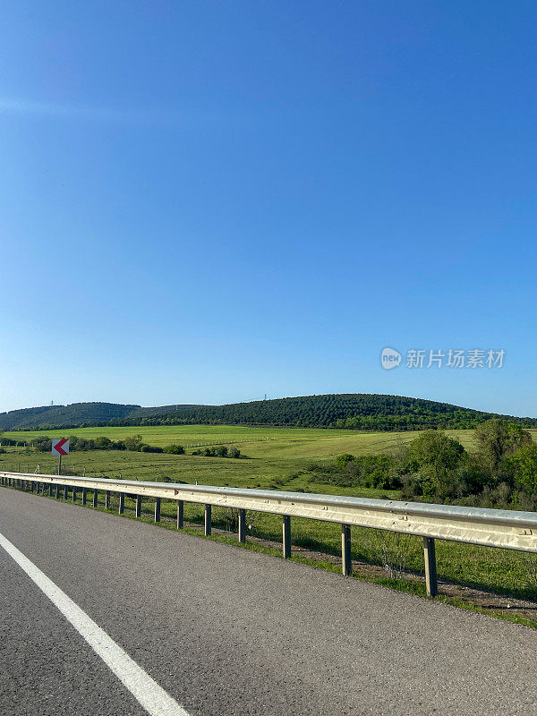 乡村道路，有晴朗的天空和山的背景