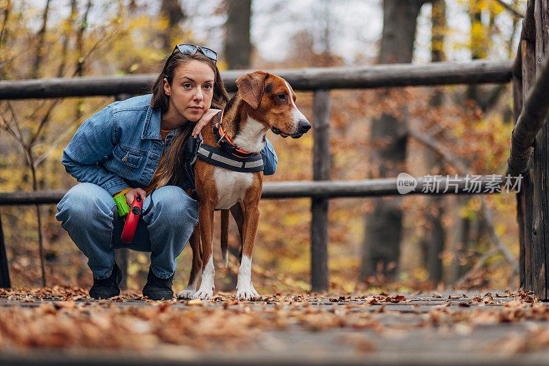 一个女人的肖像和她可爱的猎犬享受大自然，坐在门廊上