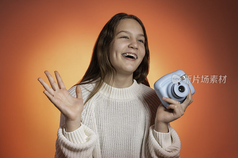 一个十几岁的女孩用宝丽来相机拍照