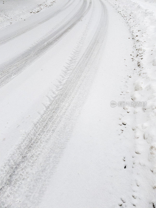 汽车轮胎印在路上刚落下的软雪上。