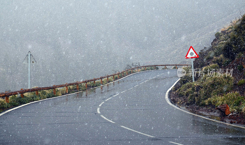 西班牙加那利群岛特内里费岛泰德国家公园的冬季降雪。冰冷的道路通过雪域火山岩石沙漠景观。
