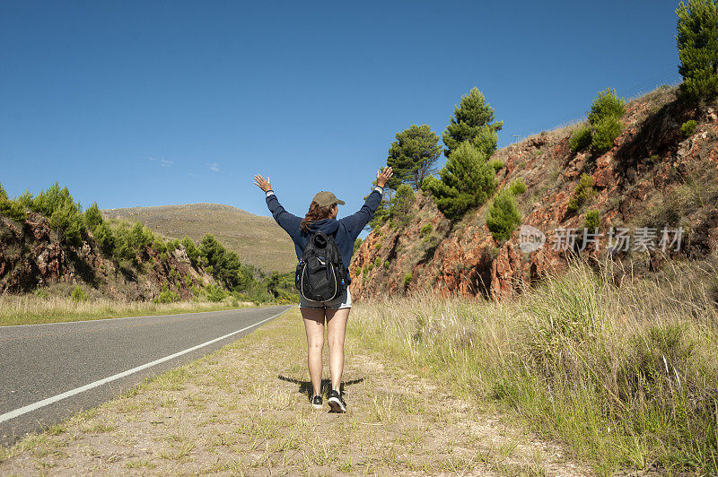 一名中年阿根廷妇女在山路上举手