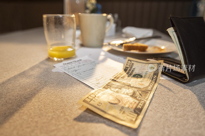 一张10美元的账单，在餐厅里买了橙汁、吐司和咖啡的日出早餐。