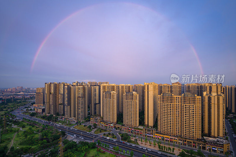 日出雨后，城市上空出现彩虹。