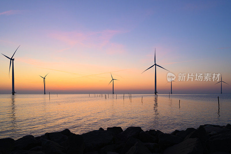 海上风力发电园区的风力涡轮机在日落时发电