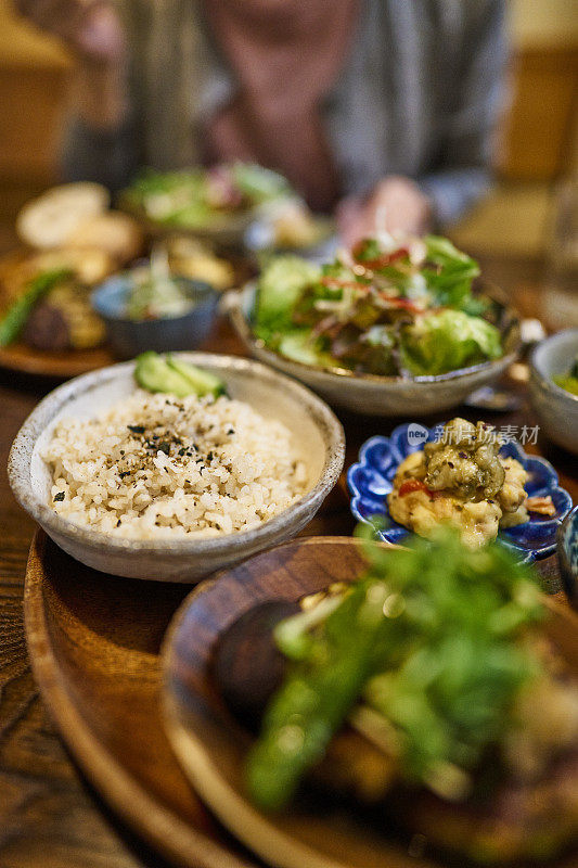 一位亚洲妇女在素食餐厅吃素食午餐。