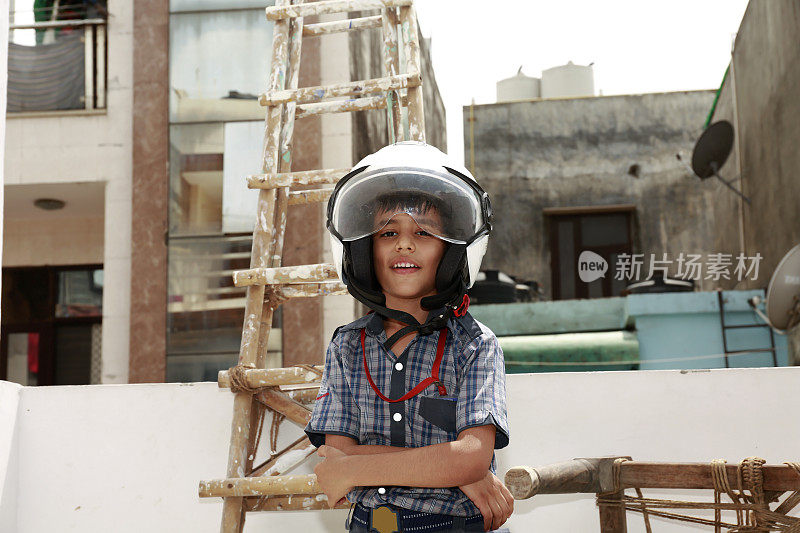 一名小学生站在梯子旁，双臂交叉