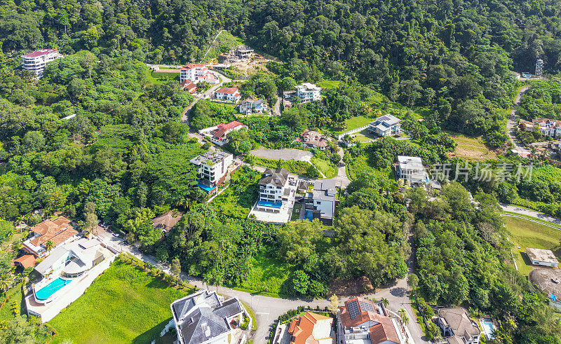 郊区树木之间的昂贵住宅的无人机视图