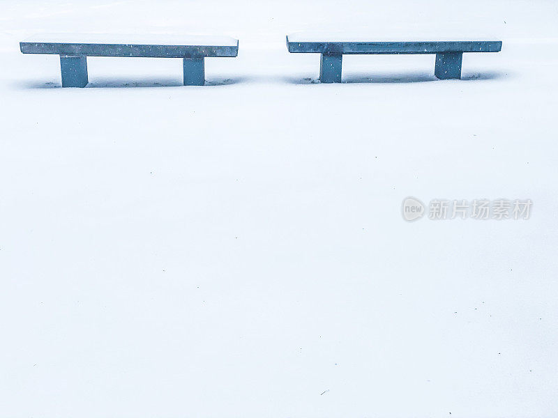 雪地里的两条长凳。