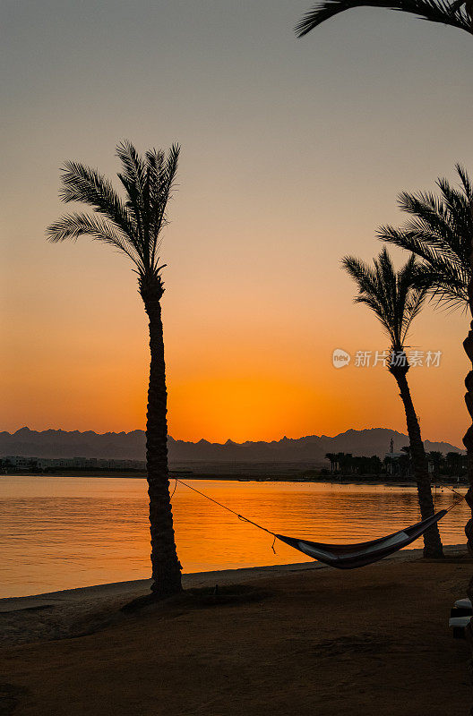 埃及赫尔格达的索玛湾，橙色的埃及日落在山脉和红海度假胜地的倒影中