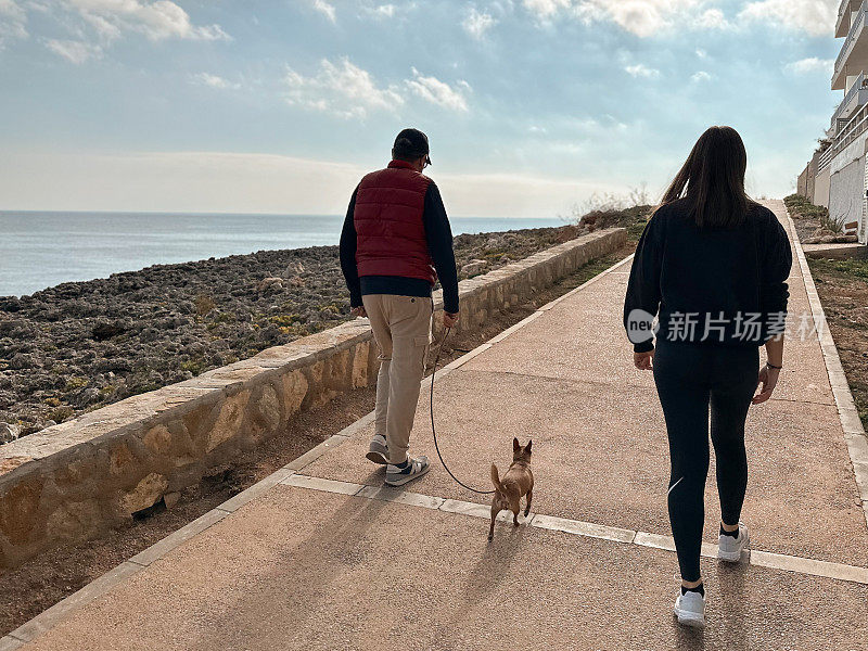 父女俩牵着他们的吉娃娃散步