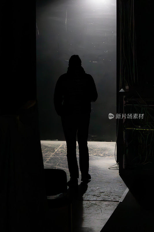 一个男人的背影在黑暗的走廊里
