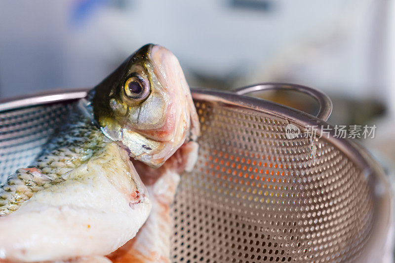 金属过滤器上未经调味的生波卡西科鱼，海鲜食品制备