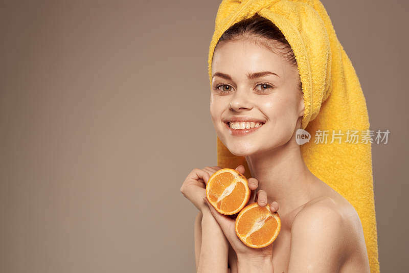 有魅力的女人裸露的肩膀，手里拿着橙子裁剪视图米色背景