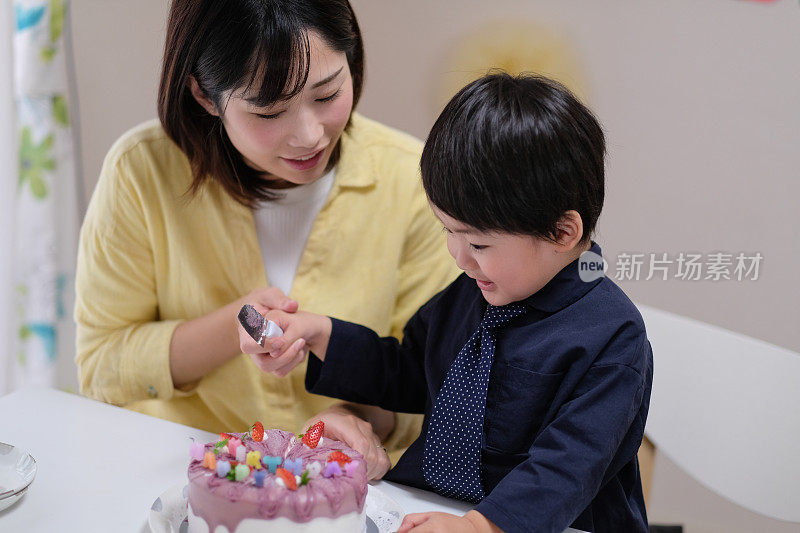 孩子和妈妈一起切生日蛋糕