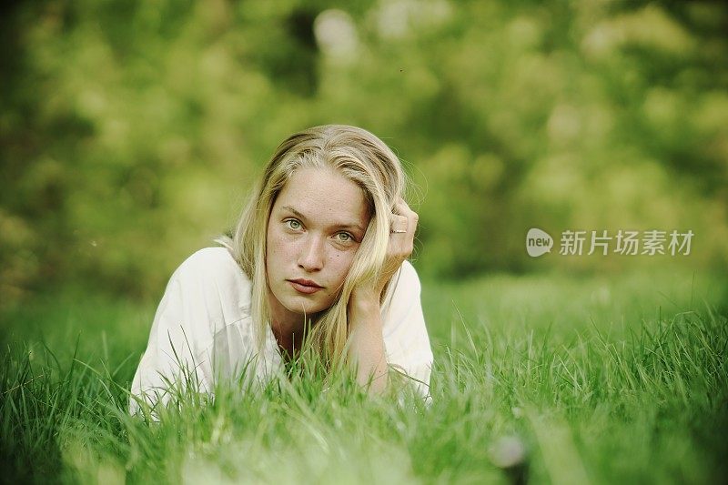 年轻女子躺在草地上