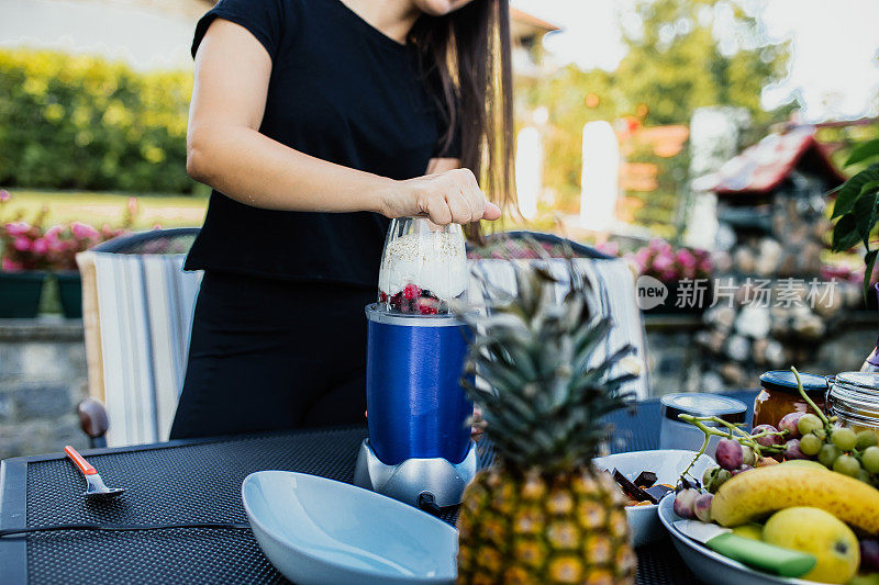 年轻女子写博客并准备健康食物