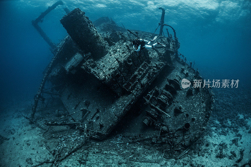 潜水员在红海靠近一艘生锈的水下沉船潜水