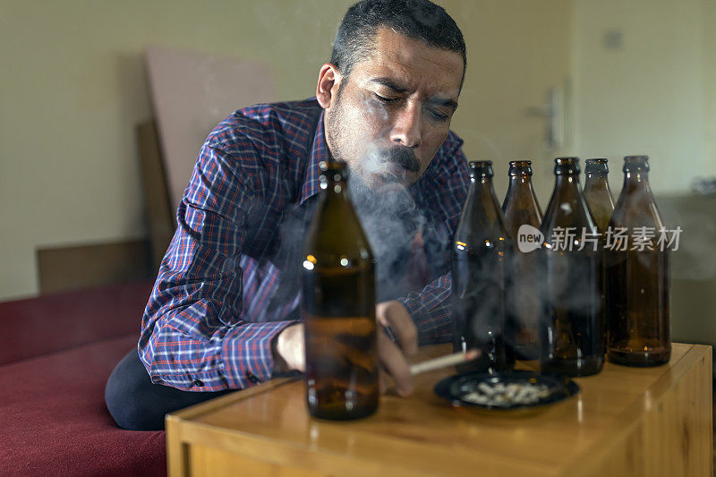 年轻悲伤的醉酒男子喝啤酒和酒精感到浪费，孤独和绝望的痛苦和情绪压力。人与酗酒、上瘾和男人抑郁的概念。