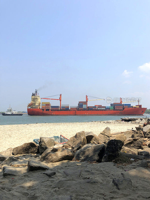 一艘巨型货船进入科钦港进行货物装卸，船只被一艘拖船停靠进入印度喀拉拉邦科钦港