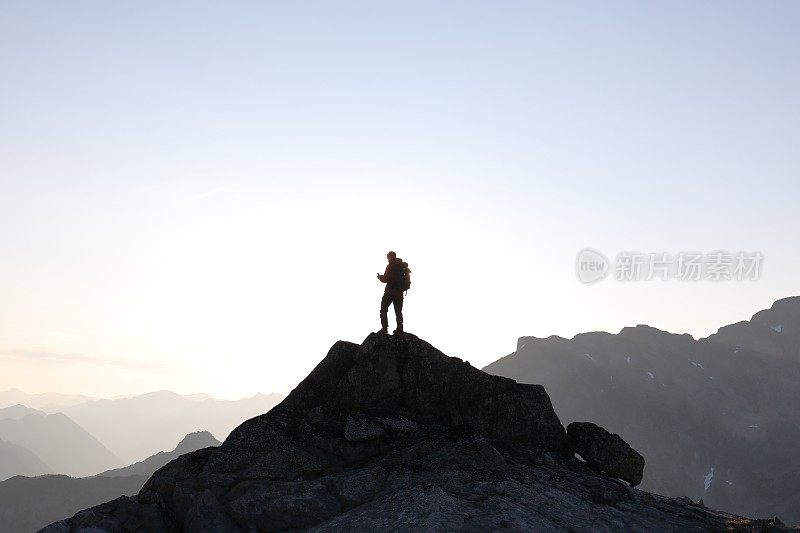 男徒步者登上山顶，日出