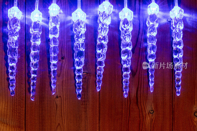 木制背景上的冰柱形状的圣诞彩灯