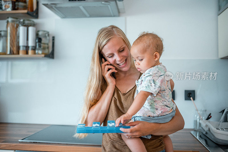 一个成熟的白人女人手里抱着她的孩子正在打电话