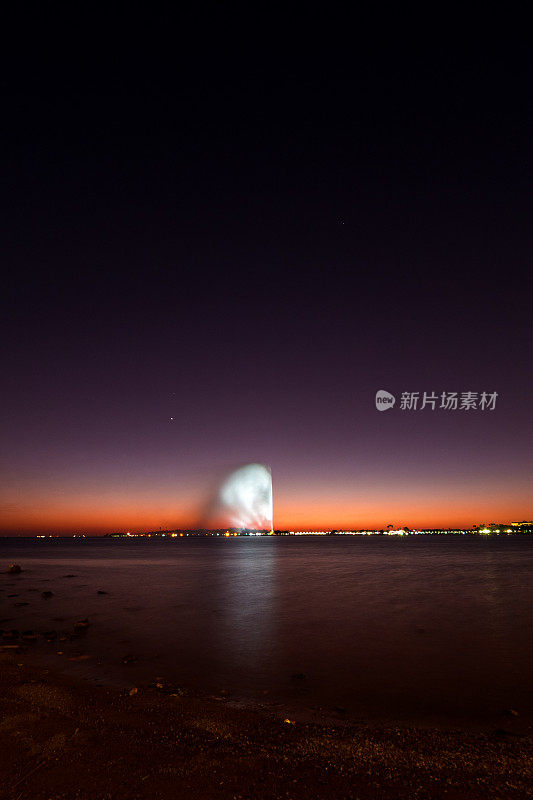 在沙特阿拉伯吉达的南滨海大道上，可以看到世界上最高的法赫德国王喷泉，背景是美丽的日落