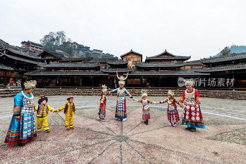 中国贵州省西江千户苗族村(千户苗族村)的中国苗族妇女和孩子穿着传统服装在露天歌剧院跳舞。