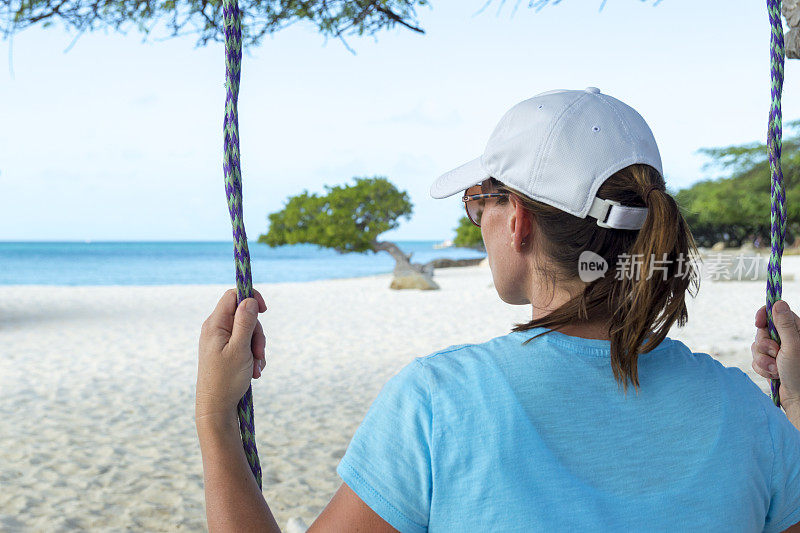 在加勒比海滩天堂荡秋千的女人