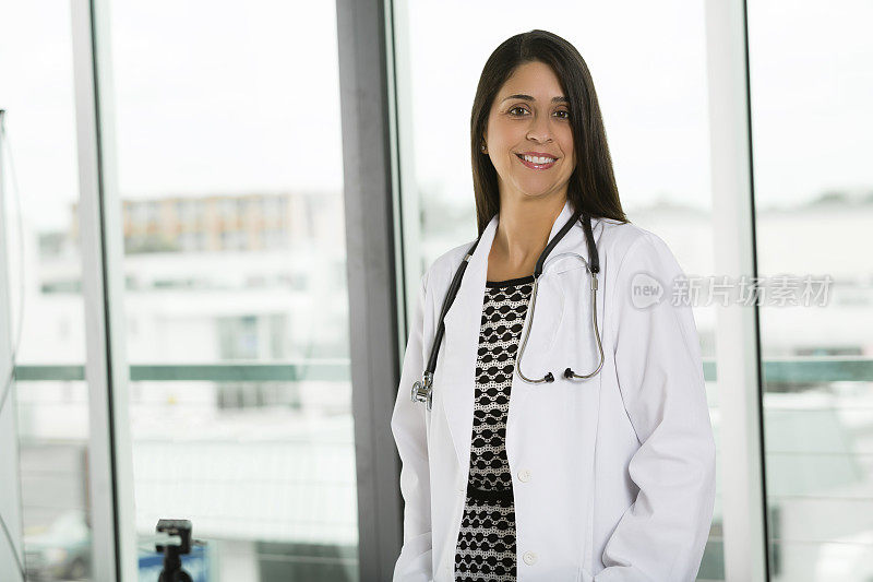 半裸的西班牙裔拉丁裔女医生微笑。