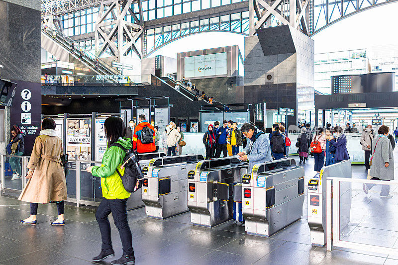 忙碌的人们使用带有现代建筑的通行证进入京都车站