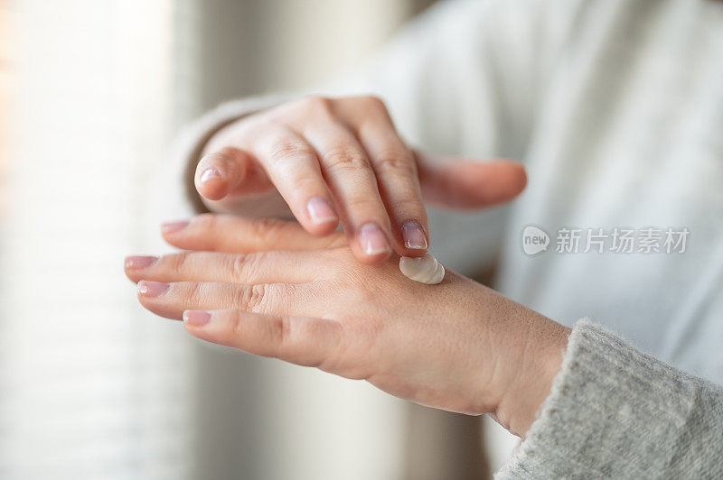 女人用护手霜擦干皮肤