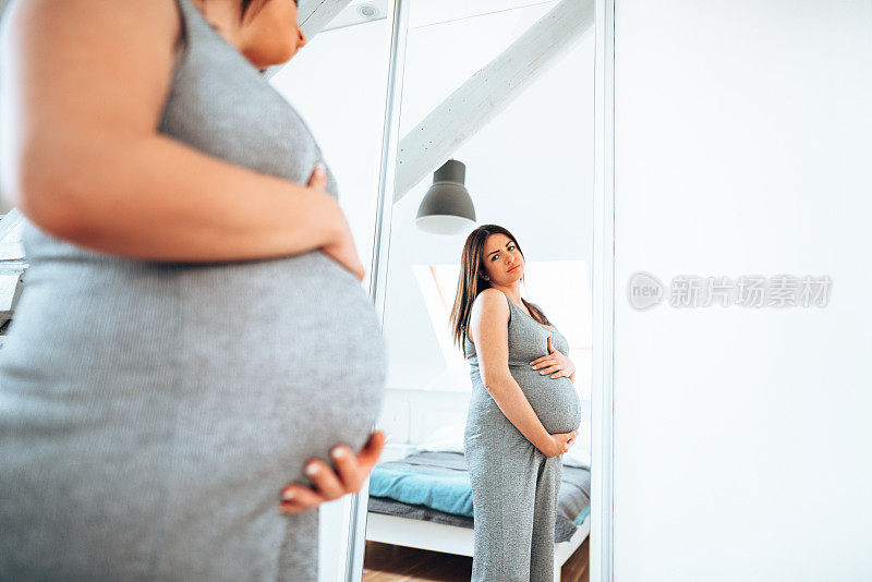 孕妇看着镜子里的自己