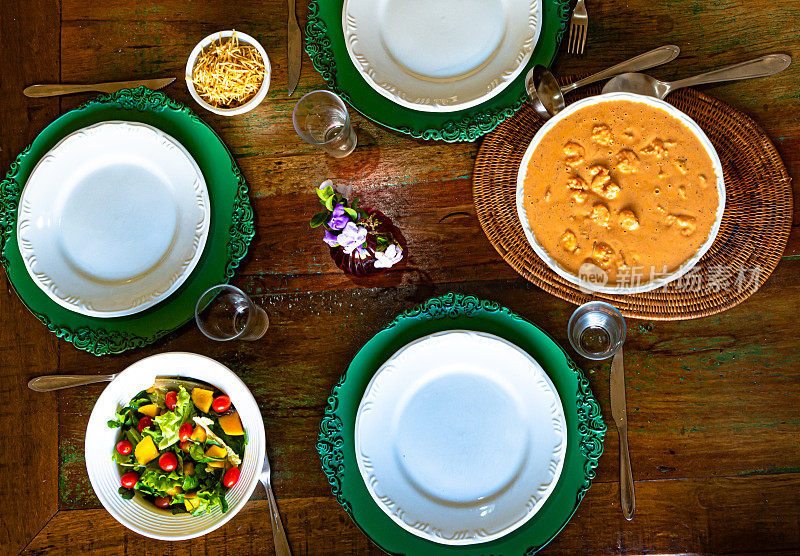 俄式鲜虾，配上白米饭、绿色沙拉、芒果和樱桃番茄，放在一张质朴的桌子上