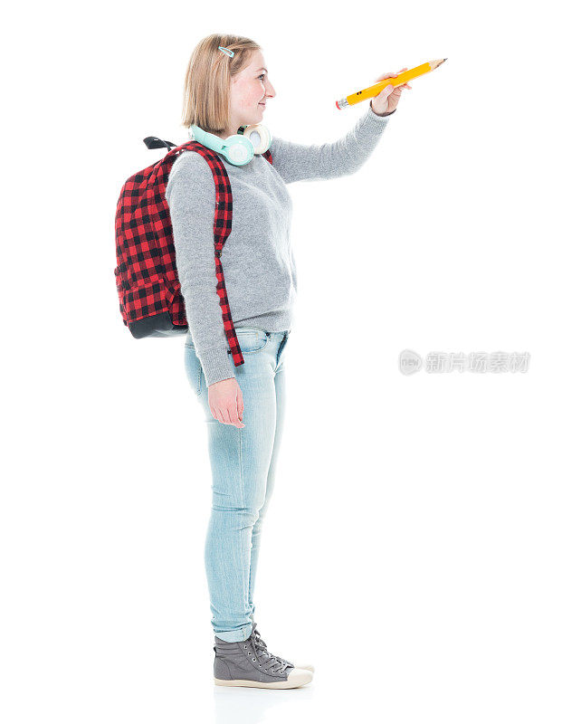 z一代年轻女教师穿着毛衣，拿着包，拿着铅笔站在白色背景前