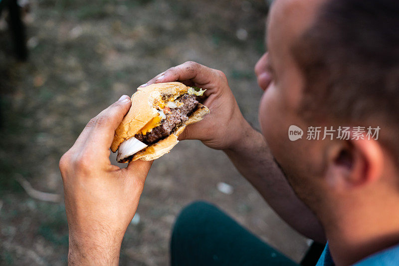 一个人在吃芝士汉堡，俯视图