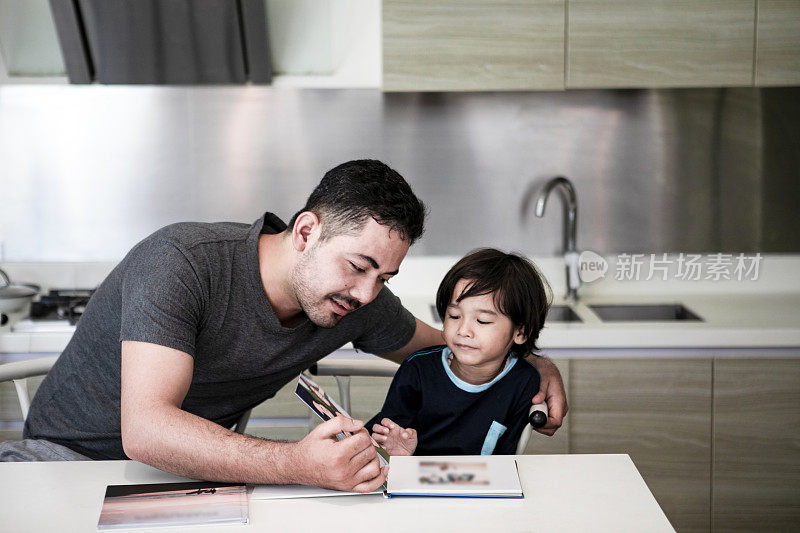 阿拉伯父亲读书与儿子在家