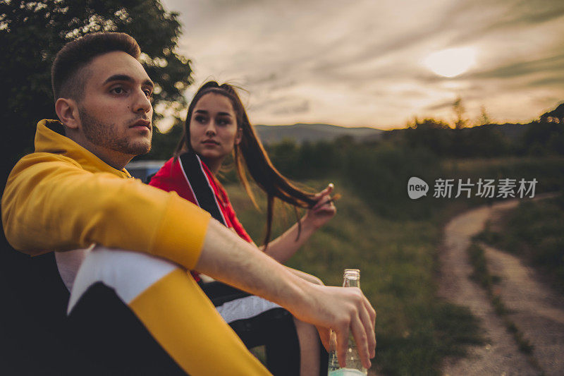 在夏日的一天和日落时分，一对愉快的夫妇在野餐时享受酒精