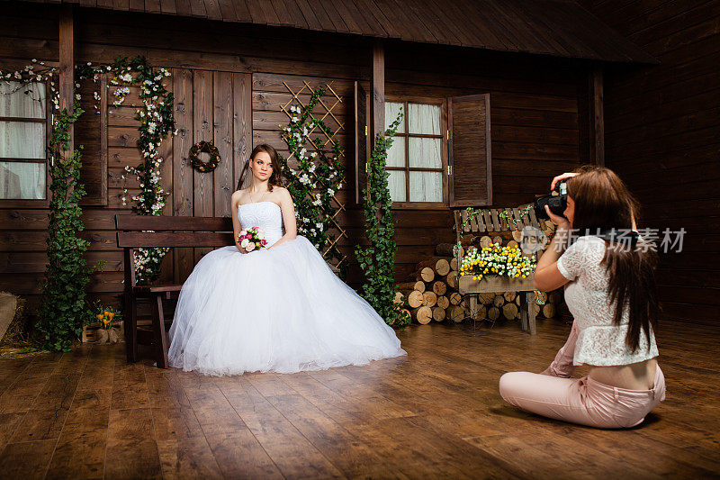 摄影师正在摄影棚里给新娘拍照