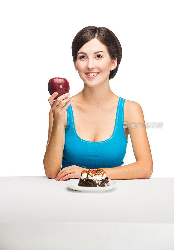 在蛋糕前拿着苹果的女人