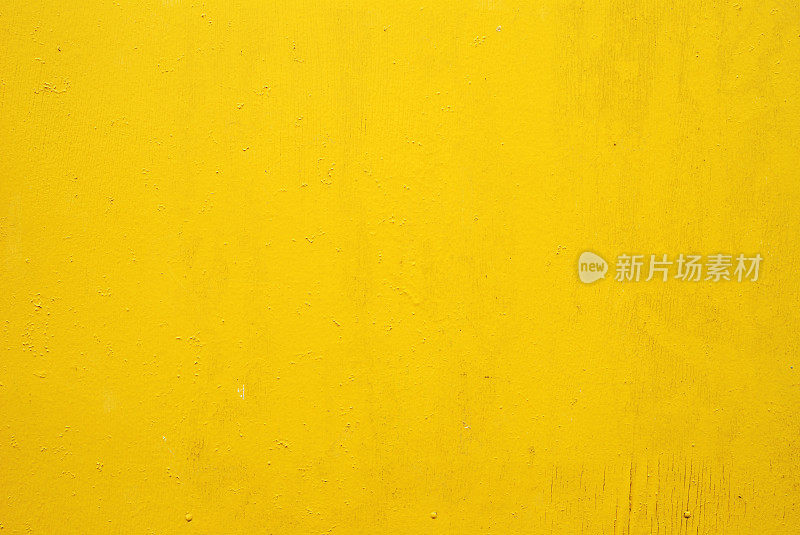 平坦的黄色墙壁上有小斑纹