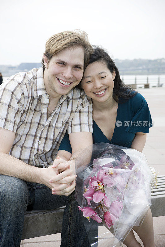 亚洲和高加索混合年轻夫妇肖像户外，花束
