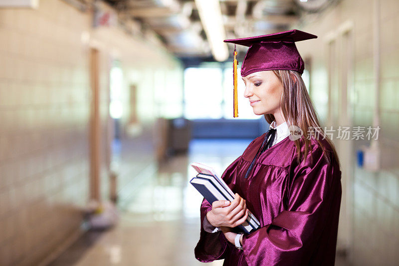 年轻的女学生穿着毕业礼服在学校