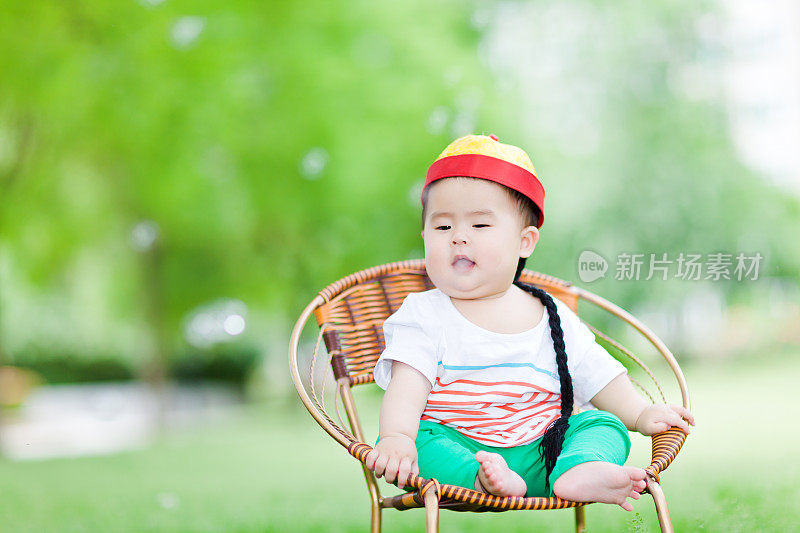 甜美的亚洲女婴坐在椅子上享受大自然