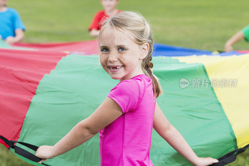 小女孩和朋友们玩降落伞
