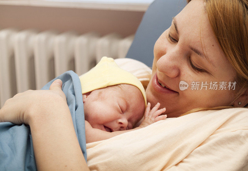 早产女婴靠在母亲的乳房上