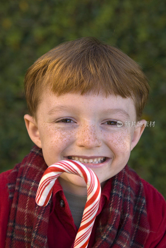 红发男孩拿着圣诞拐杖糖