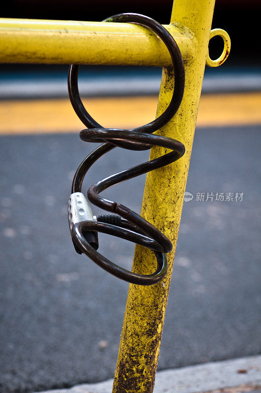 自行车链条锁附在黄色的篱笆上